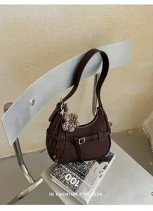 Borsa a spalla marrone in tessuto intrecciato con fibbia metallica e grazioso ciondolo fiore.