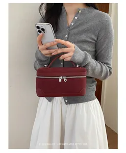 Retro suede vanity bag detail showcasing delicate handle, metal zipper, and chic aesthetic.