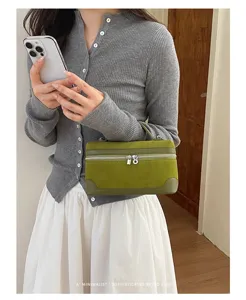 Detail view of the green suede retro lunch box handbag featuring silver dual zippers and handle.
