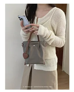 Vue detaillee du sac cabas elegant en nylon pour femme avec poignee cuir et charm coeur.