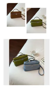 Detail view of the vintage suede vanity box bag, showing texture, dual zippers and handle.