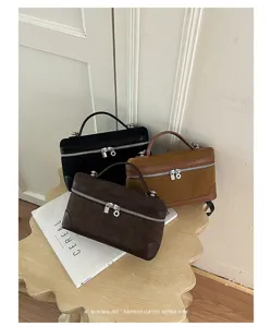 Detail view of retro suede vanity handbags, featuring structured box design and metal zippers.