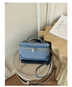 Blue retro suede vanity bag detail, elegant metal zipper and top handle design style.