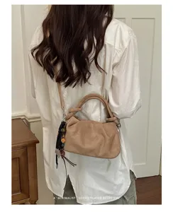 Sac bandoulière plissé en daim de style rétro minimaliste avec des poignées nouées élégantes.
