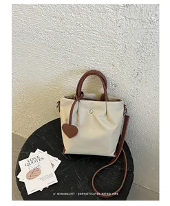 Sac seau beige minimaliste avec poignées marron, style rétro chic pour femmes au quotidien.