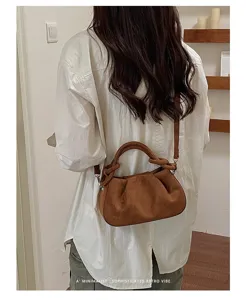 Vue détaillée du sac porté épaule plissé marron à texture mate, style rétro élégant.