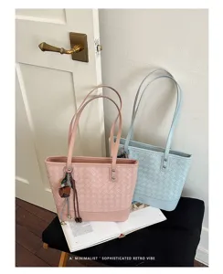 Detail van geweven PU lederen shopper tas met elegante textuur en mooie hangende bedel.