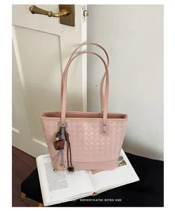 Roze geweven textuur shopper tas detail met verfijnd vakmanschap en minimalistische retrostijl.
