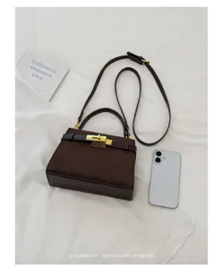 Brown suede top handle crossbody bag with gold lock and retro minimalist style design.