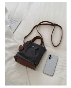 Vue détaillée du sac seau en nylon de style coréen avec bordure en cuir marron et bandoulière.