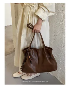 Gros plan détaillé d'un sac cabas souple en cuir marron tenu par le modèle, style.