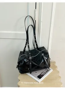 Sac à épaule en cuir verni noir avec plusieurs bretelles et œillets métalliques pour le bureau.