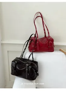 Détail du sac à bandoulière rétro en cuir verni avec double lanière et fermeture éclair.