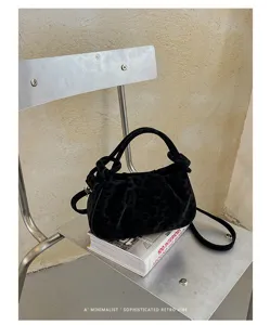 Detailed view of the chic black leopard print velvet cloud handbag with a stylish knotted handle.