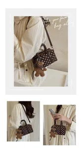 Brown polka dot boston bag detail, chic shoulder strap and cute teddy bear pendant.