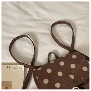 Brown polka dot mini backpack detail, stylish cute daily commuter bag texture showcase.