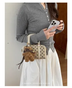 Trendy polka dot boston handbag with plush bear charm, chic retro shoulder bag for women.