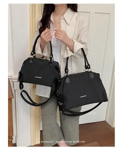 Klassische schwarze Boston-Handtasche mit vertikalen Nadelstreifen und Schultergurt.