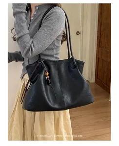 Vue détaillée du sac cabas souple noir minimaliste, style rétro sac à épaule chic.