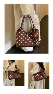 Detailed shot of the brown polka dot shoulder bag showcasing the cute bear pendant accessory.