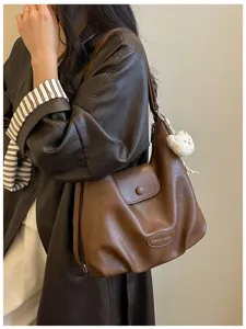 Dettaglio borsa a spalla in ecopelle marrone, design vintage con simpatico ciondolo orsetto chic.