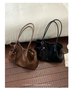 Détail du sac cabas souple minimaliste, style rétro avec pompon tressé et doubles anses.