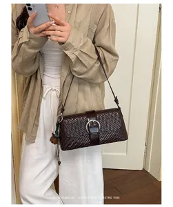 Detailed view of the dark brown woven leather shoulder bag showcasing the metal buckle.