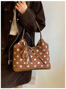 Brown suede polka dot shoulder bag detail, cute bear charm and bow decoration.
