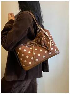 Stylish brown polka dot shoulder bag with cute teddy bear pendant, perfect for daily commute.