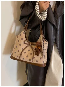 Korean style polka dot shoulder underarm bag detail, chic bow and bear pendant design.