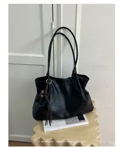 Vue détaillée du sac cabas souple en cuir noir, style rétro minimaliste quotidien.