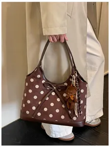 Stylish brown polka dot shoulder bag with cute bear pendant for daily commute and use.