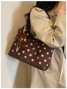Brown polka dot shoulder bag with cute bow and bear pendant for women daily commuting.