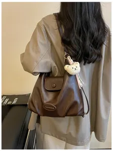 Vista dettagliata della borsa in pelle marrone retro indossata dietro, con design morbido.