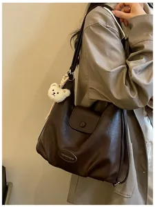 Borsa a tracolla slouchy vintage in pelle marrone scuro con ciondolo orsetto di peluche.
