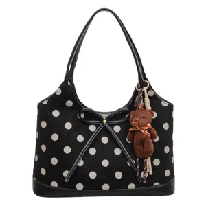 Black polka dot shoulder bag with cute bear pendant, stylish tote for women commute daily use.