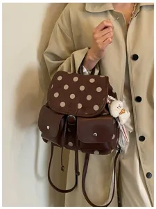 Brown polka dot backpack detail showing suede flap, leather pockets and cute puppy charm.