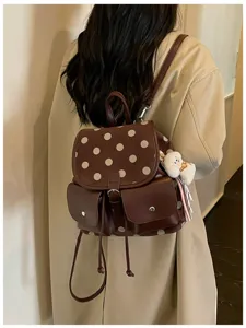 Detail view of the brown polka dot backpack showing the back wearing style and cute keychain.