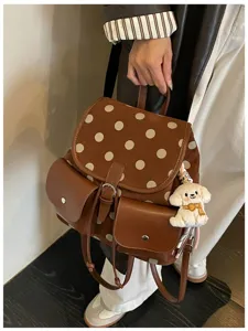 Detailed view of brown polka dot women backpack with cute puppy keychain pendant accessory