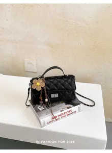Elegant black quilted chain handbag with top handle and flower charm for women autumn style.