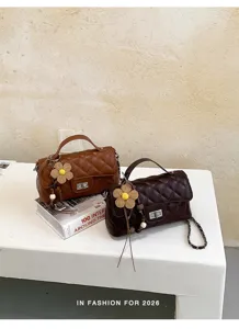 Detailed view of stylish quilted shoulder bags with chain straps and chic flower charms.