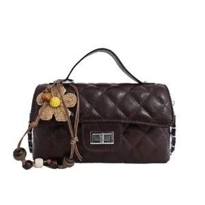 Dark brown quilted chain handbag for women with top handle and cute straw flower charm.