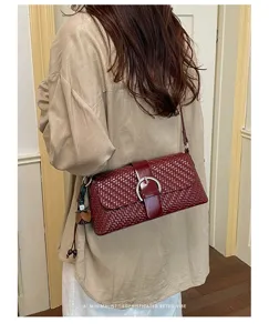 Detailed view of a chic woven shoulder bag featuring a metallic buckle and retro style.