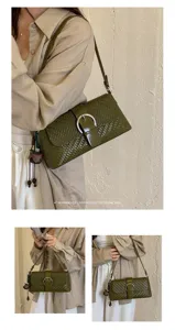 Green woven shoulder bag detail showcasing textured leather, metal buckle, and stylish bag charm.