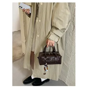 Brown retro Boston handbag detail, stylish pillow bag with buckle and charm for daily commute.