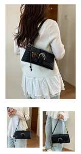 Chic black woven underarm bag for women, featuring retro metal buckle and elegant shoulder strap.