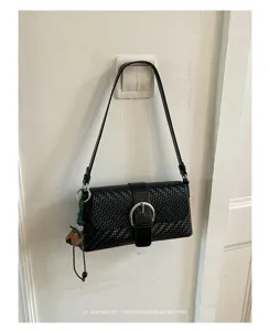 Minimalist black woven shoulder bag for women, retro baguette handbag with metal buckle.