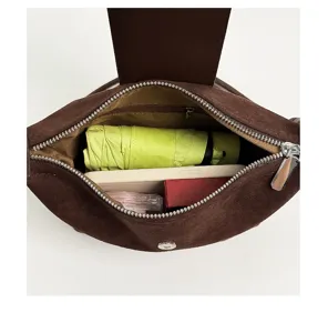 Braune Wildleder Dumpling Umhängetasche Innendetail zeigt geräumigen Stauraum für Essentials.