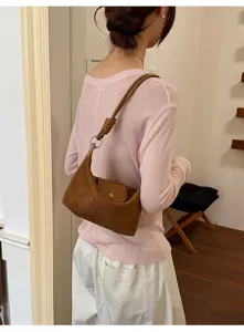 Detailaufnahme einer braunen Vintage Wildleder Umhängetasche am Model, lässiger Look.