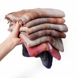 Detailed view of stacked gradient modal scarves, showing soft texture and fringe edges.